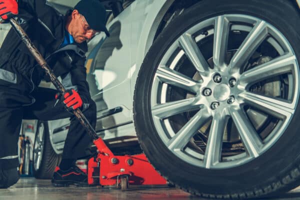 Automotive,Mechanic,With,Floor,Jack,Car,Lift.,Vehicle,Maintenance